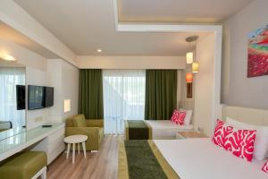 a hotel room with a bed and a living room at Orange County Alanya in Okurcalar