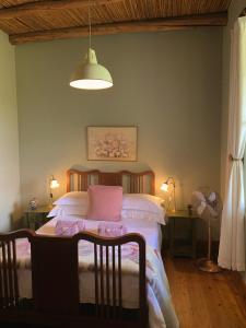 a bedroom with a bed and a table and a lamp at Rosehaven Cottage in Swellendam