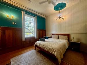 a bedroom with a bed and a window and a chandelier at Minto Accommodation Brisbane in Brisbane