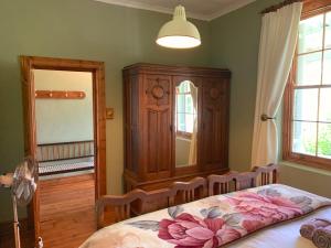 a bedroom with a bed and a cabinet and a window at Rosehaven Cottage in Swellendam