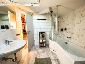 a bathroom with a white tub and a sink at Loft-Wohnung im Herzen von Prien - 100m2 - SmartTV in Prien am Chiemsee +22 photos