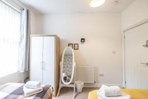 1 dormitorio con espejo, 1 cama y vestidor en 4 bedroom Townhouse en West Bromwich