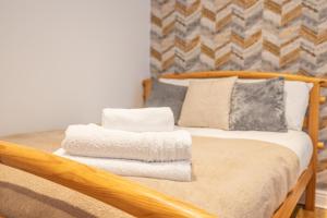 Una cama con toallas y almohadas. en 4 bedroom Townhouse en West Bromwich
