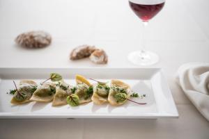 un plato de comida en una mesa con una copa de vino en Das Panorama Dependance, en Caldaro