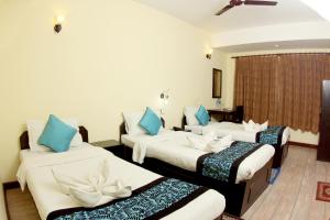 una camera d'albergo con tre letti con cuscini blu di Bag Packer's Lodge a Kathmandu Altre 37 foto