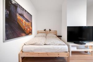 um quarto com uma cama e uma televisão de ecrã plano em Ruhige Oase in der Nähe von Parkanlage und Krankenhaus em Graz