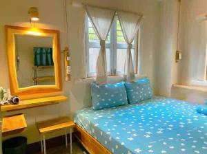 um quarto com uma cama azul e um espelho em Tropical Garden Oasis Villa em Phu Quoc