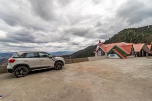 a white car parked in front of a building at Treebo Trend Snow View Resort in Shimla