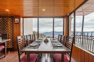 a dining room with a long table with chairs at Treebo Trend Snow View Resort Kufri With Mountain View in Shimla