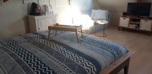 a bedroom with a bed with a table and a tv at Eendrachtweg 4 in De Cocksdorp