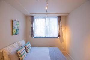 1 dormitorio con cama y ventana en Your best choice for travel in Yoyogi Y01g, en Tokio