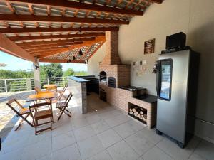 an outdoor kitchen with a table and a stove at Casa de Campo Terra Preta in Mairiporã