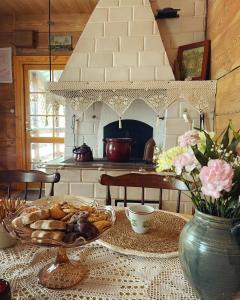 a table with a plate of bread and a vase with flowers at Aczarowane Kojły 7 in Kojły
