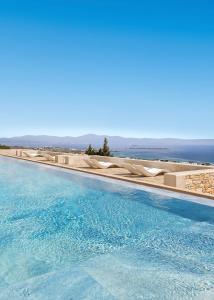 a swimming pool with the ocean in the background at Calme Boutique Hotel - Adults Only in Drios