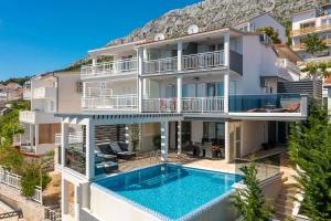 una imagen de un edificio con piscina en Luxury Seafront Villa with Heated Pool, Jacuzzi, Sea View, 150 m from Beach, en Stanići