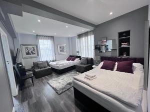 a bedroom with a large bed and a couch and a chair at Hyde Park Studio Flats in London