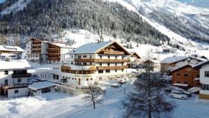 une ville dans la neige avec une montagne dans l'établissement Hotel Valisera, à Galtür