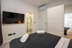 1 dormitorio con 1 cama y TV en la pared en Villa A, en Bilice