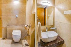 twee foto's van een badkamer met toilet en wastafel bij FabHotel Prime Ambassador in Pune