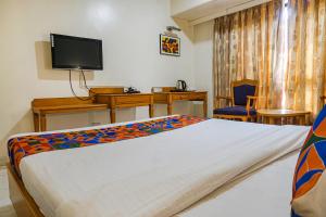sypialnia z łóżkiem, biurkiem i telewizorem w obiekcie FabHotel Prime Ambassador w mieście Pune