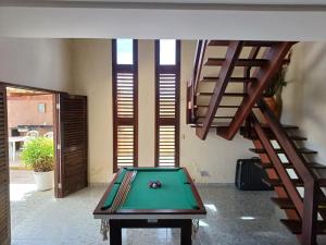 - un billard au milieu d'une pièce avec un escalier dans l'établissement Casa de Praia beira-mar, à Lucena