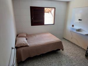 - une chambre avec un lit dans une pièce dotée d'une fenêtre dans l'établissement Casa de Praia beira-mar, à Lucena