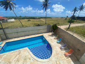 - une piscine bordée de chaises et de palmiers dans l'établissement Casa de Praia beira-mar, à Lucena