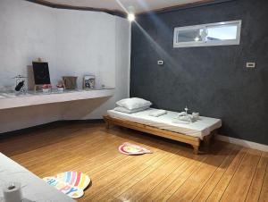a room with a bed on a wooden floor at Little Cabins at Km 499 