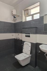 a bathroom with a toilet and a sink at Hobiz Serviced Apartments Chalakuzhy Nr Medical College Trivandrum in Trivandrum