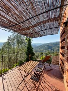 um pátio com uma mesa de madeira e cadeiras numa varanda em Agriturismo La Fontaccia em Rufina