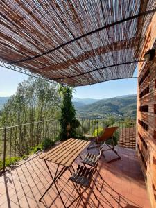 a patio with a wooden table and chairs on a balcony at Agriturismo La Fontaccia in Rufina