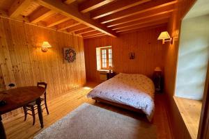 een slaapkamer met een bed en een tafel in een kamer bij Le Nid de Pajonnière en chartreuse in Saint-Pierre-de-Chartreuse