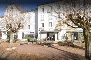 a large white building with trees in front of it at Studio des Thermes 2* in Vittel