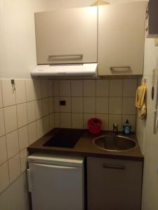 a small kitchen with a sink and a microwave at Studio des Thermes 2* in Vittel