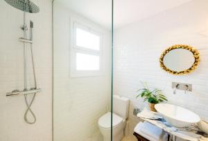 een badkamer met een wastafel, een toilet en een spiegel bij Apartamento Corall in Blanes
