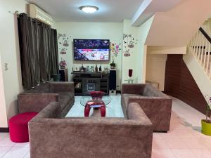 a living room with two couches and a tv at Hideaway House Patong in Patong Beach