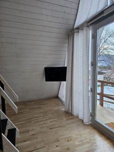 een woonkamer met een tv en een raam bij La Căsuțe Luxury in Piatra Neamţ