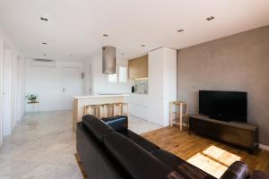 een woonkamer met een bank en een flatscreen-tv bij Apartamento Corall in Blanes +11 foto's