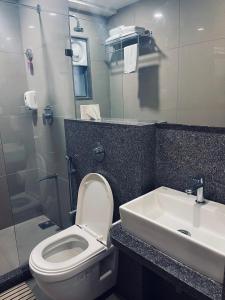 a bathroom with a toilet and a sink at The Park Residency in Ahmedabad
