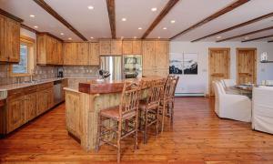 a kitchen with wooden cabinets and a bar with stools at Black Eagle 29 in Big Sky