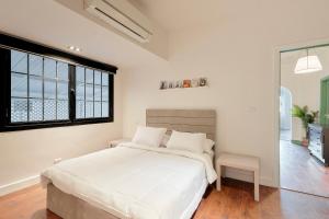 um quarto branco com uma cama grande e uma janela em Designer Baron Palace 4BR Garden Duplex no Cairo
