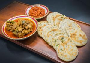 a plate of food with bread and a bowl of dip at KUMA'S HOTEL in Weligama