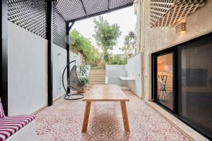 uma mesa de madeira sentada numa varanda de uma casa em Designer Baron Palace 4BR Garden Duplex no Cairo