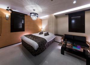 una camera con un grande letto e un lampadario a braccio di hotel SWEET SEASON a Hashima
