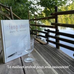un panneau assis sur une table avec un verre de vin dans l'établissement Entre rivière & bambous / Vue rivière / Parc arboré, à Saint-Juéry