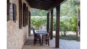 une table et des chaises assises sur une terrasse dans l'établissement trullo degli ulivi con piscina e vasca per bambini, à San Michele Salentino