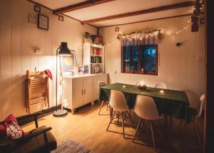 a dining room with a green table and chairs at Jarzębinowa - artystyczny dom na Podlasiu in Łuka