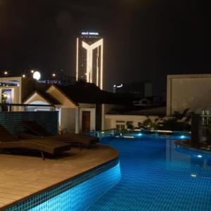 una piscina notturna con un edificio sullo sfondo di SALA HOTEL HUE a Hue
