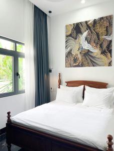 una camera da letto con un letto e un dipinto sul muro di Tây Homestay 968 a Ấp Thanh Sơn (1)
