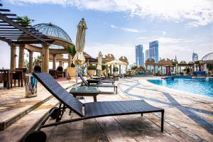 uma piscina com espreguiçadeiras e um guarda-sol em Difc 1 Bd apartment in Park Tower em Dubai